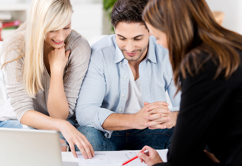 Two clients are happily discussing design decisions that must be made. The Building Designer is outlining the choices, depending on whether you need to build, expand, renovate, or extend.