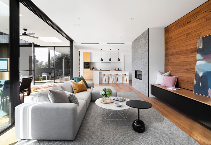 Interior design of new living and kitchen areas of new contemporary style house, with large glass opening doors leading to outdoor alfresco and terrace