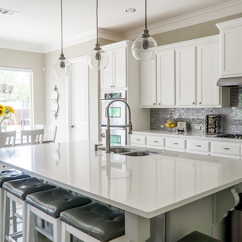 Style of kitchen used on a recent project. This style of kitchen with island bench containing sink, taps, built in dishwasher, and bar stools or chairs, gas stove, and pendant lights, was used on a recent renovation project.